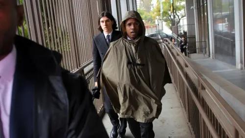 A$AP Rocky يتجول في المحكمة مرتديًا معطفًا واقيًا، برفقة شخص آخر، وسط أجواء من التوتر خلال محاكمته بتهمة الاعتداء.