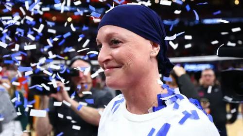 مدربة فريق ولاية بنسلفانيا كاتي شوماخر-كاولي تحتفل بفوز فريقها ببطولة NCAA للكرة الطائرة وسط قصاصات ملونة بعد المباراة.