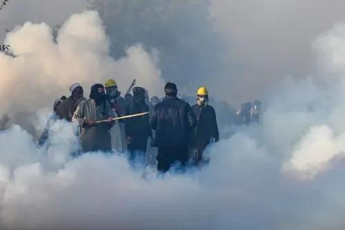 متظاهرون يرتدون خوذات وقناع الغاز وسط سحب من الغاز المسيل للدموع خلال احتجاجات في إسلام أباد للمطالبة بإطلاق سراح عمران خان.