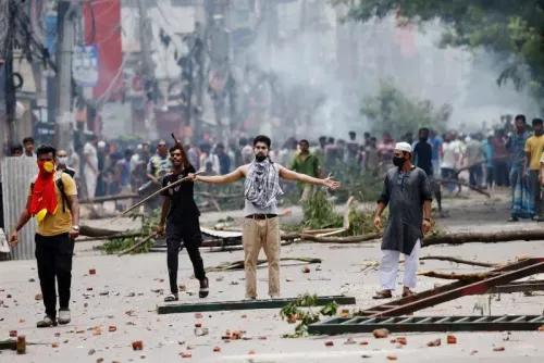 محتجون يتظاهرون في بنغلاديش خلال احتجاجات عنيفة، مع وجود حطام وأشخاص يرتدون أقنعة، في سياق الاضطرابات السياسية.