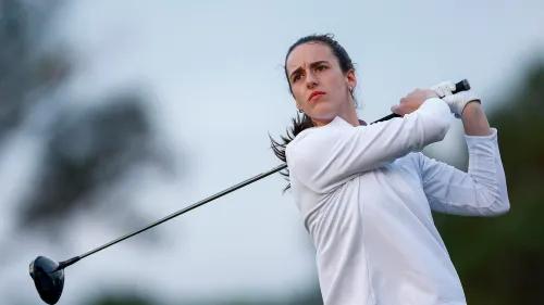 كيتلين كلارك تضرب كرة الغولف في بطولة ANNIKA Pro-Am، مرتدية زيًا أبيض، مع تركيز واضح على وجهها.