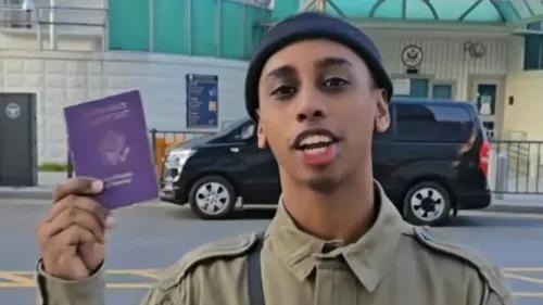 مقدم برامج البث المباشر \"جوني الصومالي\" يحمل جواز سفره في سيول، كوريا الجنوبية، بعد اتهامه بالتسبب في فوضى في متجر.