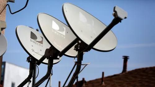 أطباق الأقمار الصناعية لشركة DirecTV مثبتة على سطح منزل، تعكس التوجه نحو دمج خدمات الأقمار الصناعية في ظل المنافسة مع منصات البث.