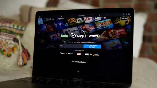 واجهة موقع ديزني بلس تعرض خيارات الاشتراك مع شعارات خدمات ديزني وHulu وESPN، وسط خلفية تحتوي على مشاهد من أفلام كرتونية.