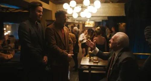 مشهد من مسلسل "Hacks" يظهر شخصيات رئيسية في حوار داخل بار، مع أضواء دافئة وأجواء نابضة بالحياة تعكس طابع البرنامج الكوميدي.