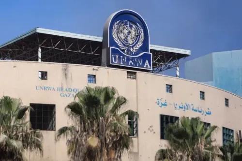 مبنى الأونروا في غزة، يظهر شعار الأمم المتحدة، مع نخل في المقدمة، يعكس جهود الوكالة في تقديم المساعدات للاجئين الفلسطينيين.