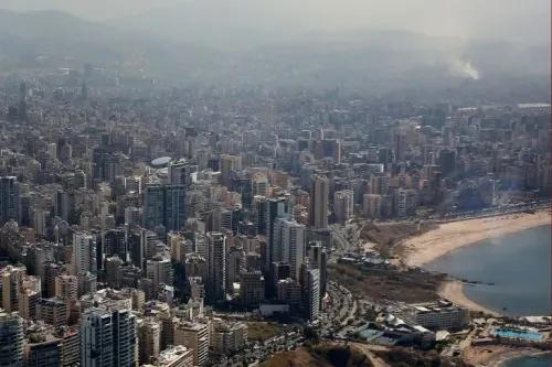 صورة جوية لمدينة بيروت تُظهر الكثافة العمرانية والمباني الشاهقة على الساحل، تعكس الوضع الاقتصادي والمالي المتدهور في لبنان.