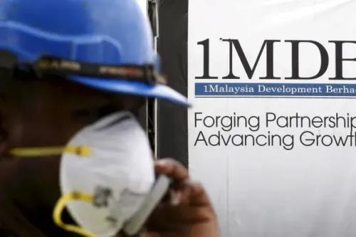 عامل يرتدي خوذة وقناعًا واقيًا، يقف أمام لافتة لصندوق 1Malaysia Development Berhad (1MDB) التي تشير إلى الشراكات والنمو.