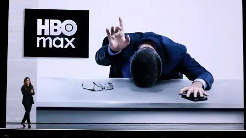 إعلان عن إعادة تسمية منصة ماكس إلى HBO Max، مع ظهور شخصية في بدلة تجلس أمام طاولة، تعبر عن الإحباط.