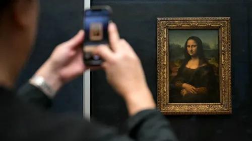شخص يلتقط صورة للوحة "الموناليزا" في متحف اللوفر، حيث ستخضع للتحديث والتوسيع لجعل الزيارة أكثر سهولة للزوار.