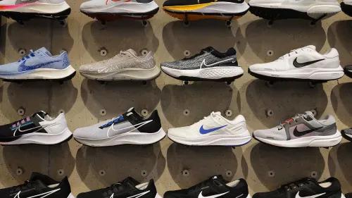 مجموعة من أحذية Nike الرياضية مرتبة على جدار، تمثل التحديات التي تواجهها الشركة في السوق والمنافسة المتزايدة.