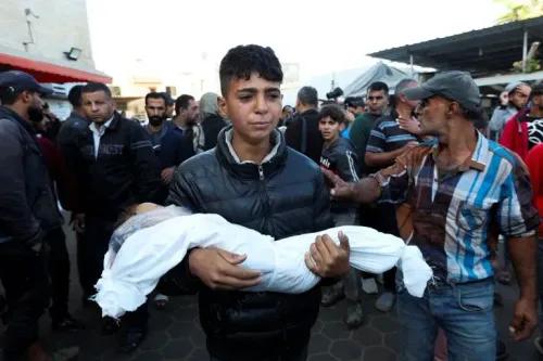 طفل يحمل جثة رضيعة وسط حشد من الناس في غزة، يعكس مشهد المعاناة الإنسانية في ظل الصراع المستمر.