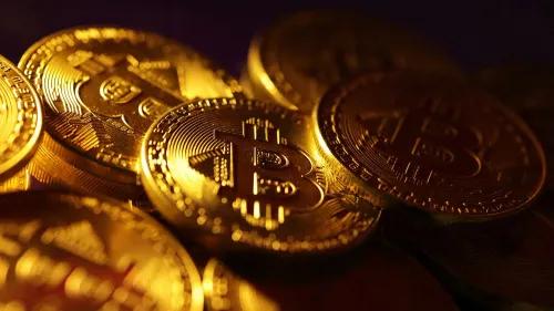 عملات بيتكوين الذهبية تتجمع معًا، مما يبرز أهميتها كأصل رقمي رئيسي في عالم العملات المشفرة.