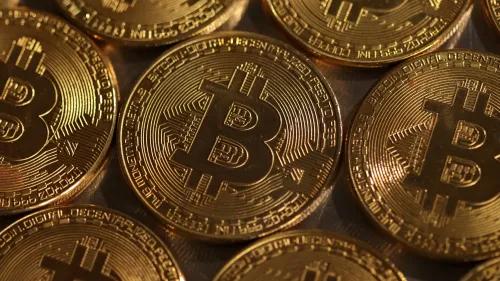 تظهر الصورة مجموعة من عملات البيتكوين الذهبية، مما يرمز إلى أهمية تخفيض المكافآت وتأثيره المحتمل على قيمة العملة الرقمية.