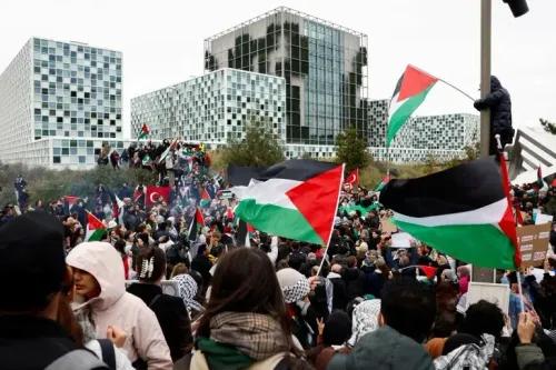 مظاهرة حاشدة أمام المحكمة الجنائية الدولية في لاهاي، حيث يحمل المتظاهرون الأعلام الفلسطينية تعبيرًا عن الدعم للعدالة في غزة.