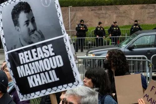 لافتة تحمل صورة محمود خليل وكلمة "أطلقوا سراح محمود خليل" خلال احتجاجات تطالب بالإفراج عنه، مع وجود شرطة خلفية.