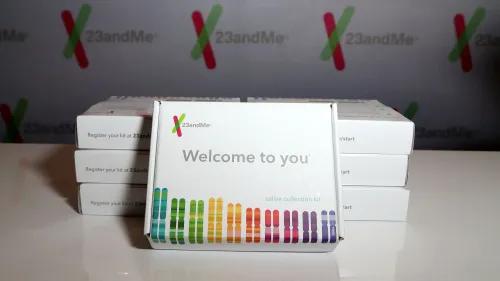 صندوق مجموعة اختبار الحمض النووي من 23andMe، مع شعار الشركة، يبرز في الخلفية تفاصيل عن الحمض النووي.