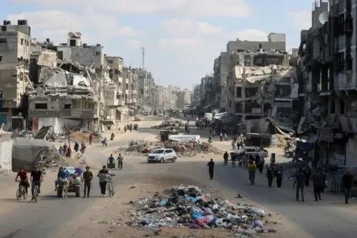 شوارع شمال غزة المدمرة، مع وجود سكان يتجولون بين الأنقاض، مما يعكس آثار الحصار والاعتداءات الإسرائيلية.