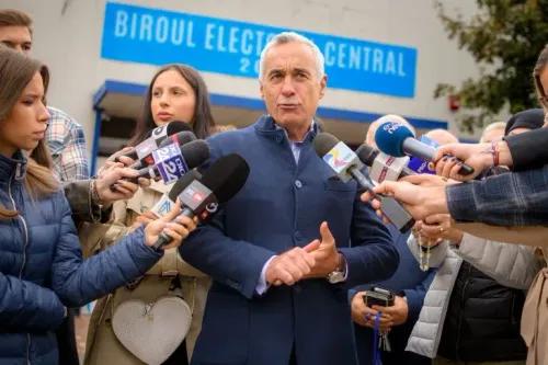 كالين جورجيسكو، المرشح الرئاسي الروماني، يتحدث للصحفيين أمام مركز انتخابي، محاطًا بعدد من المراسلين والميكروفونات، وسط أجواء انتخابية.