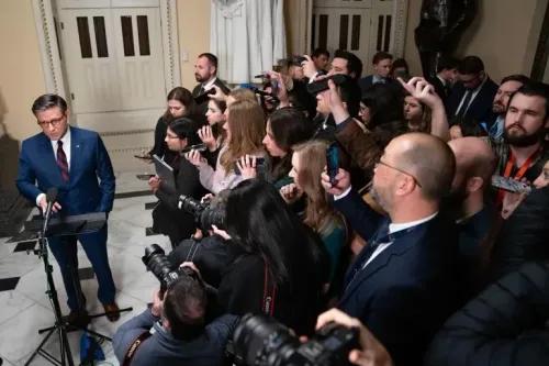 مراسل يتحدث أمام حشد من الصحفيين في مبنى حكومي، وسط أجواء من التوتر بعد رفض قانون الإنفاق الأمريكي.